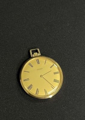 a close up of a gold pocket watch with roman numerals