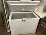 a white chest freezer in a kitchen next to a stove
