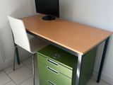 a desk with a computer and a chair in the corner