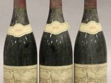 trois bouteilles de vin sont alignées sur une table