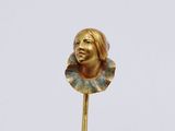 a gold statue of a woman with a flower on a stick