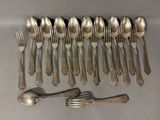 a lot of silver spoons and forks laid out on a table