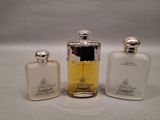 three bottles of perfume sitting next to each other on a white surface