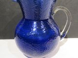 a blue glass pitcher sitting on a white table