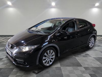 La Honda Civic noire est garée dans une salle blanche.