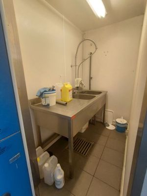 une cuisine équipée d'un évier et d'un plan de travail sur lequel est installé un robinet