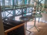 des tables et des chaises dans un restaurant, avec un tableau noir devant elles