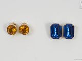 deux paires de boucles d'oreilles en saphir et citrine sur un fond blanc