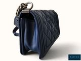 the small blue purse has a chain hanging from it ' s side