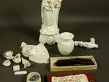 a statue of a woman holding a child next to other items