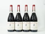 quatre bouteilles de vin sont alignées sur une surface blanche