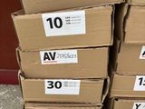 des cartons de différentes tailles et couleurs contenant du matériel électrique, empilés les uns sur les autres