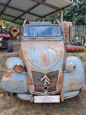 a rusted out old truck parked under a covered structure