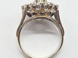 a close up of a diamond ring on a white surface