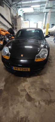 a black sports car parked in a garage next to motorcycles