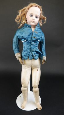 une poupée qui porte une veste bleue et un pantalon blanc
