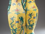 pair of yellow and green vases with dragon designs on them