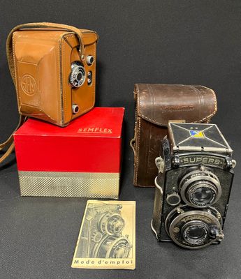 three old cameras and a box of money on a table