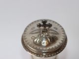 a silver box with a cross on it on a white surface