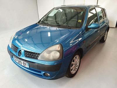 La voiture bleue est garée dans le garage, la porte ouverte.