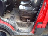 a red truck with a black suitcase in the back of it