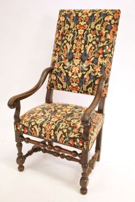 an old chair with a floral upholstered back and arms