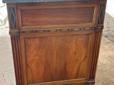 a wooden cabinet with a marble top on a brick floor