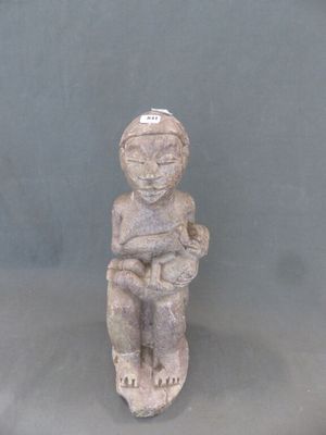 une statue représentant un homme assis sur un tabouret, coiffé d'un chapeau