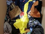 a cardboard box filled with clothes and a handbag