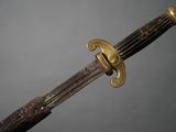 a close up of a sword with a wooden handle