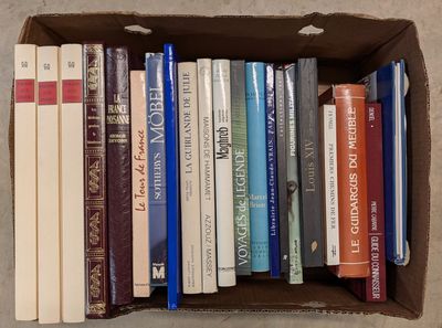 une boîte remplie de livres posés sur le sol