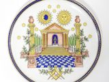 une image représentant une assiette décorative sur laquelle figure un symbole maçonnique