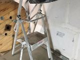a ladder with a bag on top of it in a room