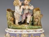 une figurine représentant deux enfants assis sur un banc