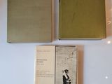 three books on display in a glass case on a white surface