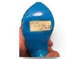 a hand holding a small blue object with a label on it