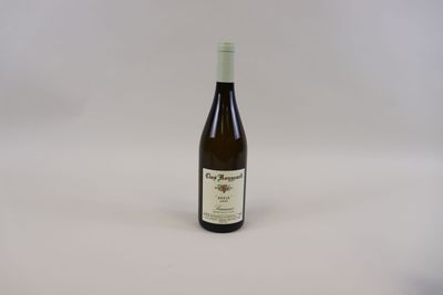une bouteille de vin posée sur une table blanche