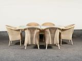 a table with four chairs around it on the concrete floor