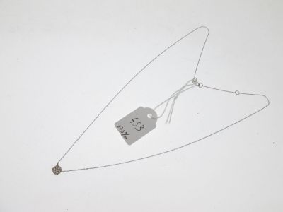 un collier auquel est attachée une étiquette sur une surface blanche