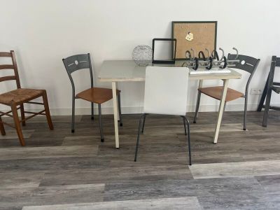 several chairs and a table in a room with a picture on the wall