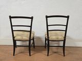 pair of black chairs against a white wall in a room