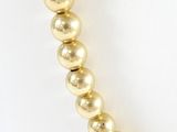 a close up of a gold bead necklace on a mannequin mannequin