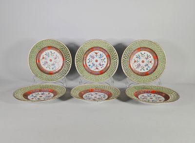 quatre assiettes ornées de motifs floraux, posées sur une surface blanche