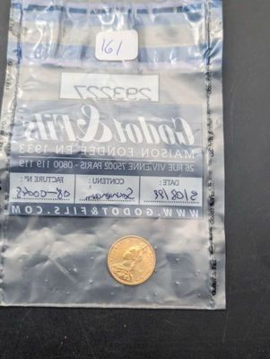 une pièce d'or dans un sachet en plastique posé sur une table