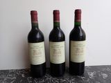 three bottles of wine are lined up on a table