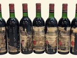 six bottles of red wine are lined up in a row