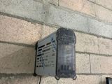 une boîte fixée sur le côté d'un mur de briques