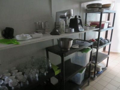 une étagère sur laquelle se trouvent un mixeur, un saladier, des tasses et d'autres ustensiles de cuisine