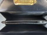 a black purse with a gold buckle on it