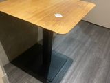 une table en bois avec un piètement noir dans une pièce